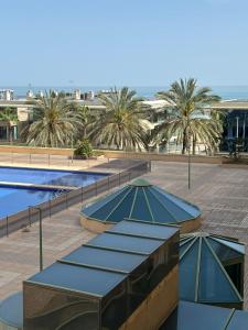 a resort with two swimming pools and palm trees at Playa Patacona vistas al mar in Valencia