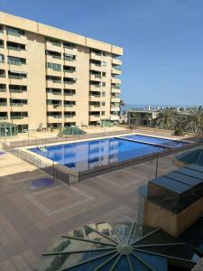 a large swimming pool in front of a building at Playa Patacona vistas al mar in Valencia