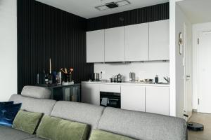 a living room with a couch and a kitchen at Skyline Blick Frankfurt - Nahe Messe in Frankfurt