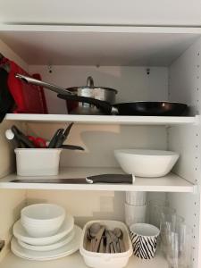 a kitchen shelf with dishes and utensils at Studio close to Malmö and Lund in Åkarp