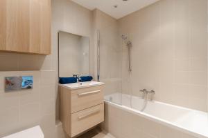 ein Bad mit einer Badewanne, einem Waschbecken und einer Dusche in der Unterkunft Magnificent 8P2BR apartment with indoor pool and garden - Deauville in Deauville