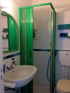 un bagno con lavandino e porta doccia verde di B&B Al Salvatore Di Lipari a Città di Lipari