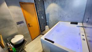 a bathroom with a tub with a toilet in it at Hotel Nova Boutique in Rajkot