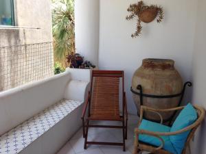 B&B Al Salvatore Di Lipari في ليباري: غرفة بها كرسي و مزهرية كبيرة