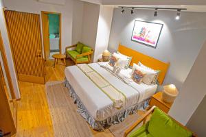 ein Schlafzimmer mit einem großen Bett und einem grünen Stuhl in der Unterkunft Hotel Nova Boutique in Rajkot