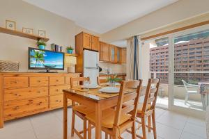 a kitchen with a table and chairs and a television at Solana Fuengirola 40 in Fuengirola