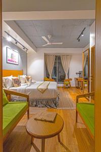 a bedroom with two beds and a table and chairs at Hotel Nova Boutique in Rajkot