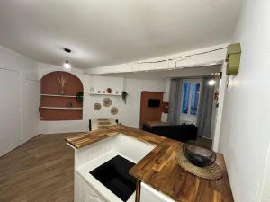 a kitchen and living room with a wooden counter top at L'escale Cévenole - Esprit Terracotta in Anduze