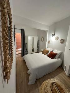 a bedroom with a large white bed in a room at L'escale Cévenole - Esprit Terracotta in Anduze