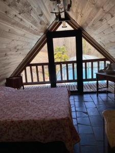 a bedroom with a bed and a large window at maison avec piscine in Illartein