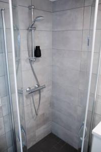 a shower with a glass door in a bathroom at Elegant Penthouse Loft - Near the Airport in Vantaa