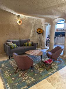sala de estar con sofá, sillas y alfombra en Casa Chilai Cappadocia, en Ürgüp