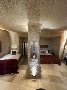 a hotel room with two beds and a stone pillar at Casa Chilai Cappadocia in Urgup