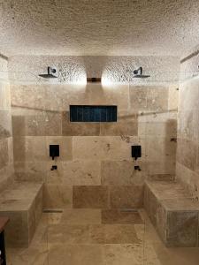 duża łazienka z prysznicem wyłożona kamiennymi kafelkami w obiekcie Casa Chilai Cappadocia w mieście Ürgüp