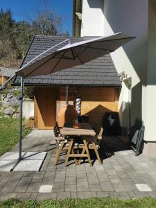 a picnic table under an umbrella on a patio at Forest House in Bled