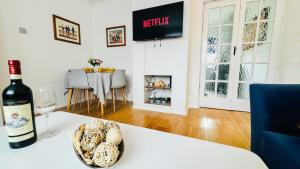 a bottle of wine and a bowl of shells on a table at "The Cromwell" I Contractor's Haven Borehamwood I 3 - 6 Beds I Free Parking, Netflix & Sky Sports in Borehamwood