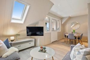 uma sala de estar com um sofá, uma televisão e uma mesa em Top-floor apartment w/great view em Bergen