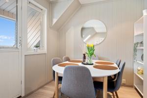 uma sala de jantar com uma mesa, cadeiras e um espelho em Top-floor apartment w/great view em Bergen