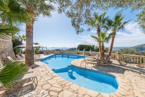 een zwembad met palmbomen in een resort bij Villa Oscols in Alcudia