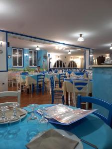 ein Restaurant mit blauen Tischen und Stühlen und einem blauen Tisch in der Unterkunft Smart Apartment by the Sea near Palermo, Sicily in Isola delle Femmine