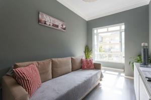 uma sala de estar com um sofá e uma janela em Be Local - Apartment with 2 bedrooms in Moscavide - Lisbon em Lisboa