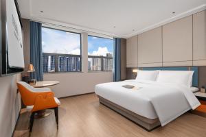 a bedroom with a large bed and a large window at Yizhi Hotel - Guangzhou East Railway Station Tianhe Sports Center in Guangzhou