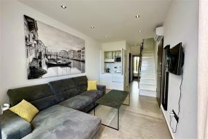 a living room with a couch and a television at White Lion Apartment N2 Kallithea in Kallithea Halkidikis