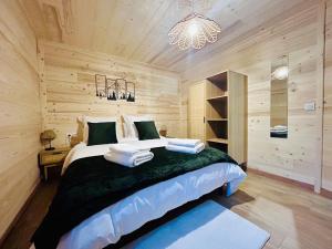 a bedroom with a large bed and a chandelier at Au P'tit Randonneur avec terrasse - CLG - 1CH - 1 SDB in Chevillard
