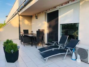 a patio with a table and chairs on a balcony at Panorama Apartman Zamardi in Zamárdi