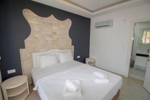 a bedroom with a white bed and a brick wall at Cihan Villa, Özel Havuzlu, Fethiye in Fethiye