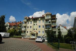 biały samochód zaparkowany przed budynkiem w obiekcie Apartament Słoneczny 7 w mieście Opole