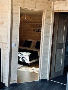 een slaapkamer met een bed in een houten hut bij Au P'tit Randonneur avec terrasse - CLG - 1CH - 1 SDB in Chevillard