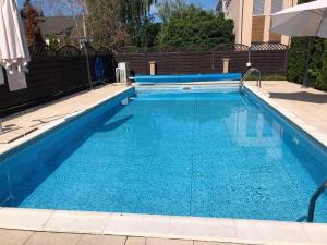 a large swimming pool with blue water at Panorama Apartman Zamardi in Zamárdi
