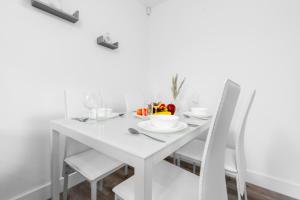 una mesa de comedor blanca con sillas blancas en Smethwick Deluxe 2 Bedroom Aparetment - Secure Parking - Balcony - Rated Exceptional - 9MC, en Birmingham