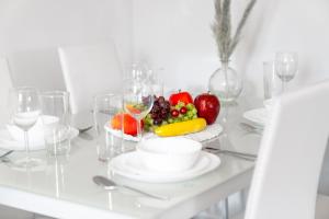 a white table with a plate of fruit and wine glasses at Smethwick Deluxe 2 Bedroom Aparetment - Secure Parking - Balcony - Rated Exceptional - 9MC in Birmingham