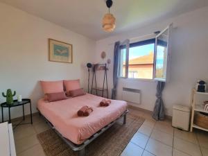 a bedroom with a bed with pink sheets and a window at Joli studio lumineux centre avec parking securise dans quartier recherche in Aix-en-Provence +9 photos