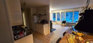 a living room with a kitchen with a table and a counter at Hammarstrandvilla in Hammarstrand