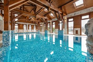SăliceaCasa Dinainte SPA Resort的建筑物内铺有蓝色瓷砖的大型游泳池