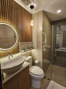 een badkamer met een wastafel, een toilet en een douche bij The Luxury Lounge in Bacolod