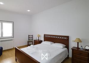 a bedroom with a large bed with white sheets at MyStay - Casa Pereira Soeima in Alfândega da Fé