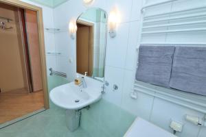 een witte badkamer met een wastafel en een spiegel bij Apartament Słoneczny 6 in Opole