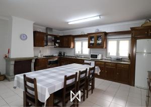 a kitchen with a table and chairs in it at MyStay - Casa Pereira Soeima in Alfândega da Fé