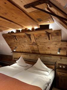 a bed in a room with wooden walls and ceilings at Romantik Hotel U Raka in Prague