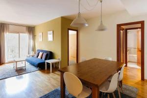 sala de estar con mesa de madera y sofá azul en Comfortable 4 rooms 2Bath w balcony, en Barcelona