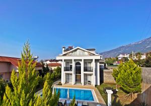 a large white house with a swimming pool at Cihan Villa, Özel Havuzlu, Fethiye in Fethiye