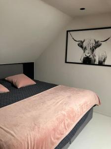 1 dormitorio con 1 cama con una foto de una vaca en La maison de Timao en Hannut