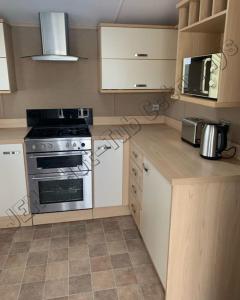 Køkken eller tekøkken på JEMs Hot-Tub Getaways 8 berth at Tattershall Lakes + 21 billeder