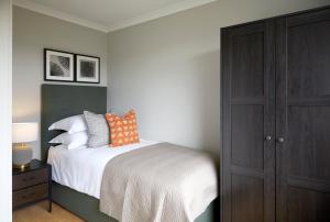 Cosy tastefully decorated flat in Rainham في رينهام: غرفة نوم بسرير وخزانة خشبية