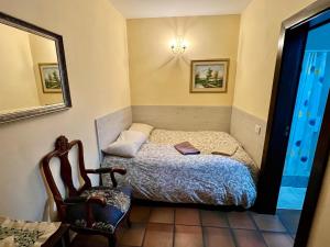 een kleine slaapkamer met een bed en een stoel bij Hotel Rural Vilaflor Self check in 24h in Vilaflor