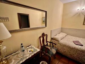 1 dormitorio con cama, espejo y silla en Hotel Rural Vilaflor Self check in 24h en Vilaflor